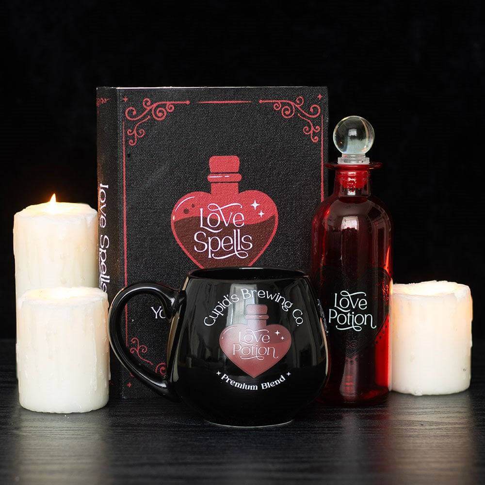 Gift set with red love potion bottle, 'Love Spells' mug, and candles
