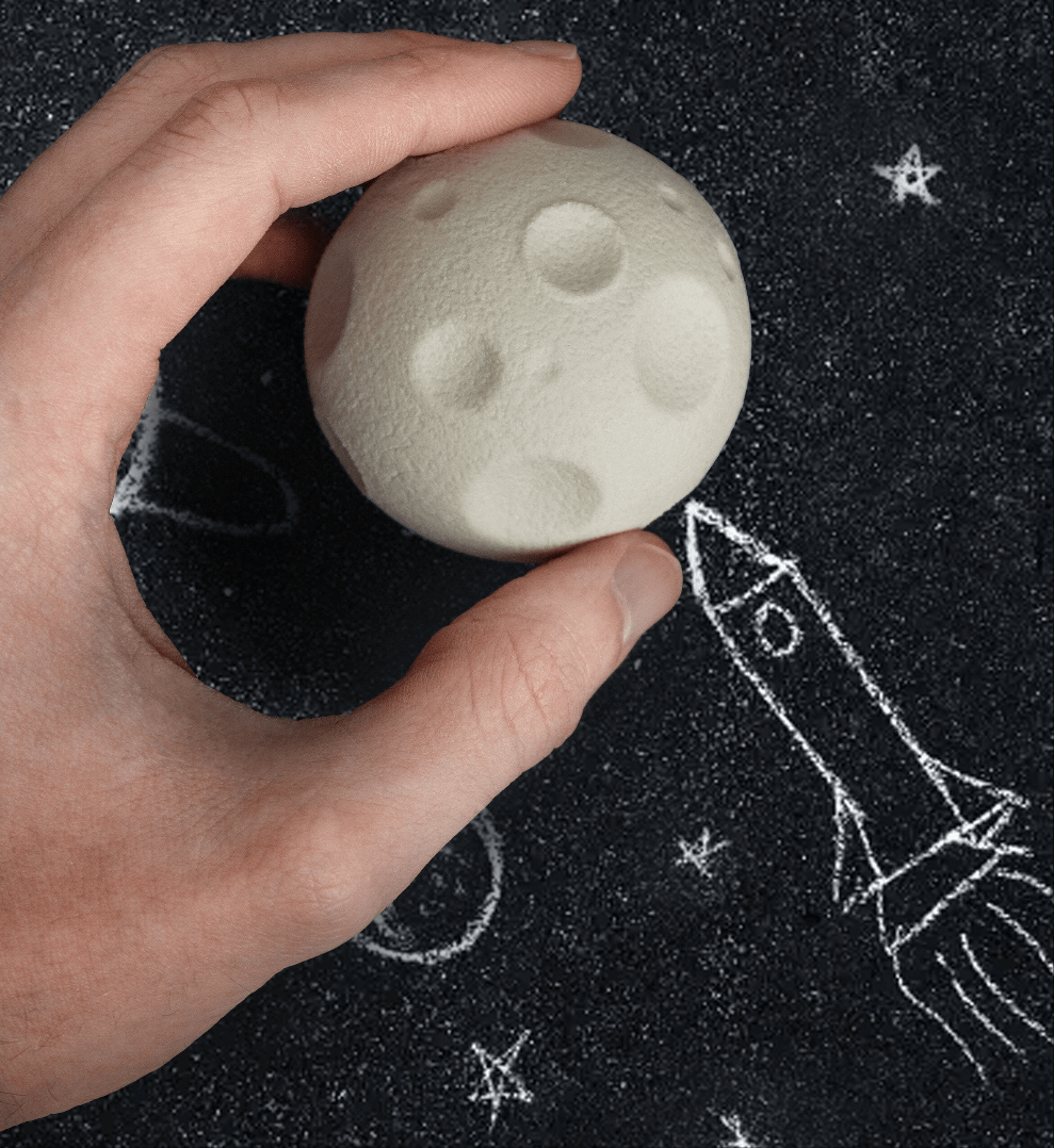 Moon-shaped rubber eraser, cream color with raised crater details, held in hand