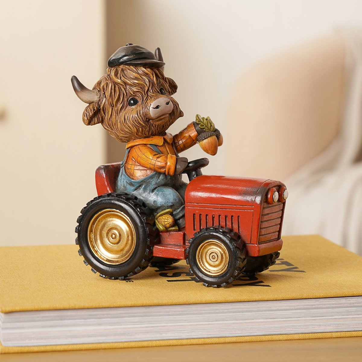 The Fashion Gift Shop: Highland Cow sits happily on a tractor, creating a charming rural scene by Country Living, Animal Ornament
