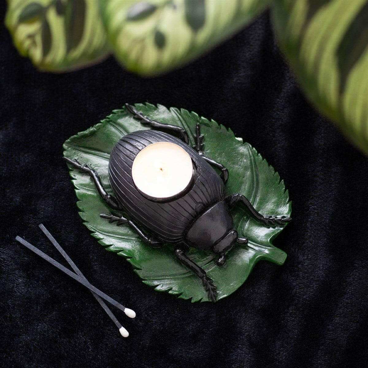 Beetle tealight candle holder with green leaf tray, black beetle, and lit white tealight
