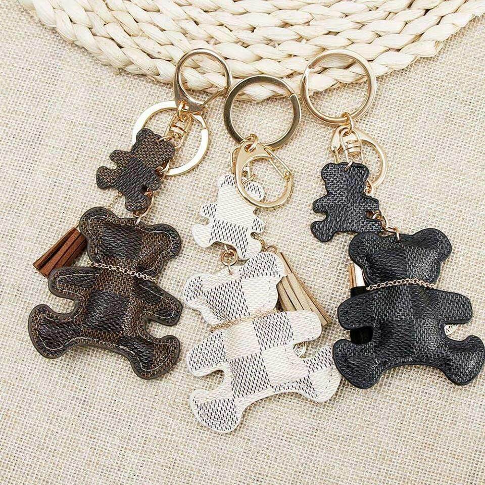 Patchwork teddy bear keyring set on woven fabric with gold rings, tassels, and coin charms