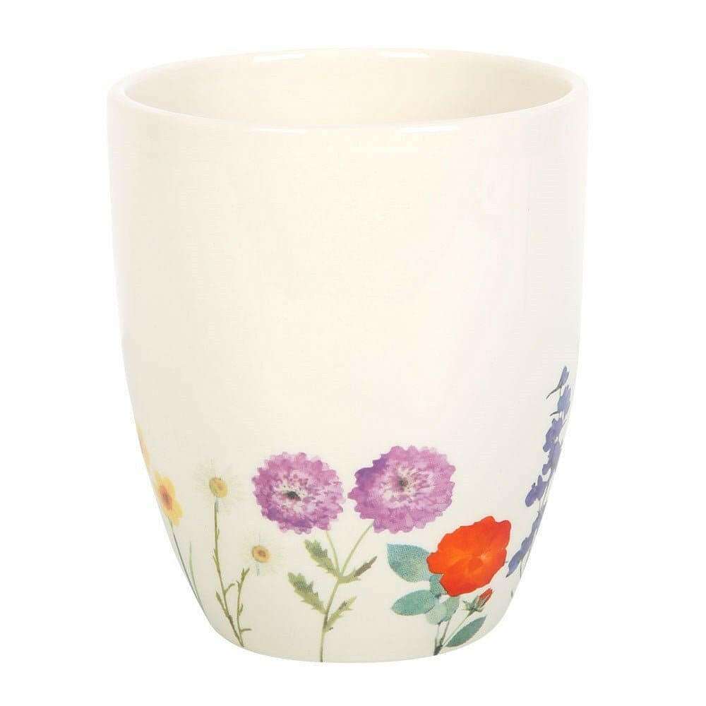 White ceramic plant pot with purple daisy-like flowers and orange poppy print