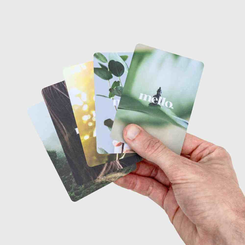 Self-help card deck, hand holding layered illustrated cards with nature scenes