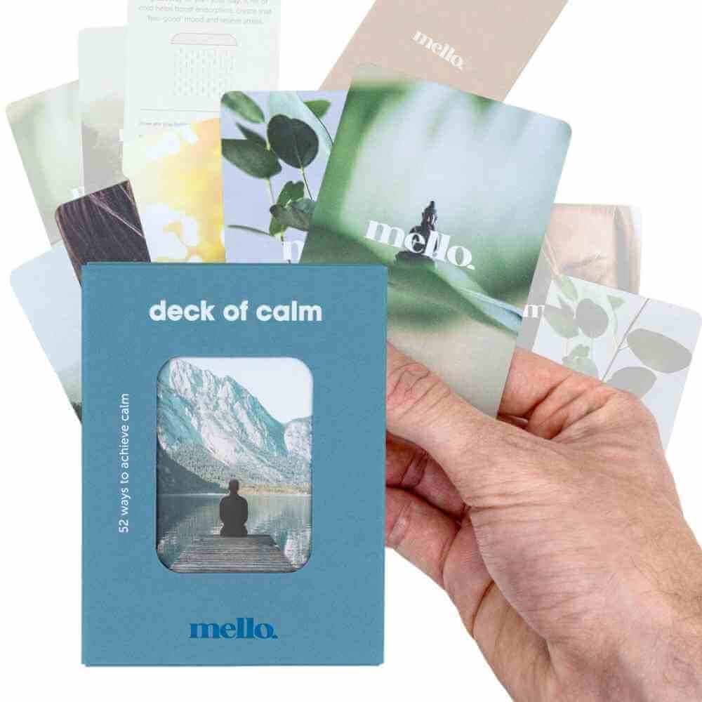 Self-help card deck with blue box and mountain card, hand holding scattered cards