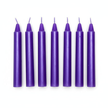 Set of six purple taper candles with wicks, arranged in a row