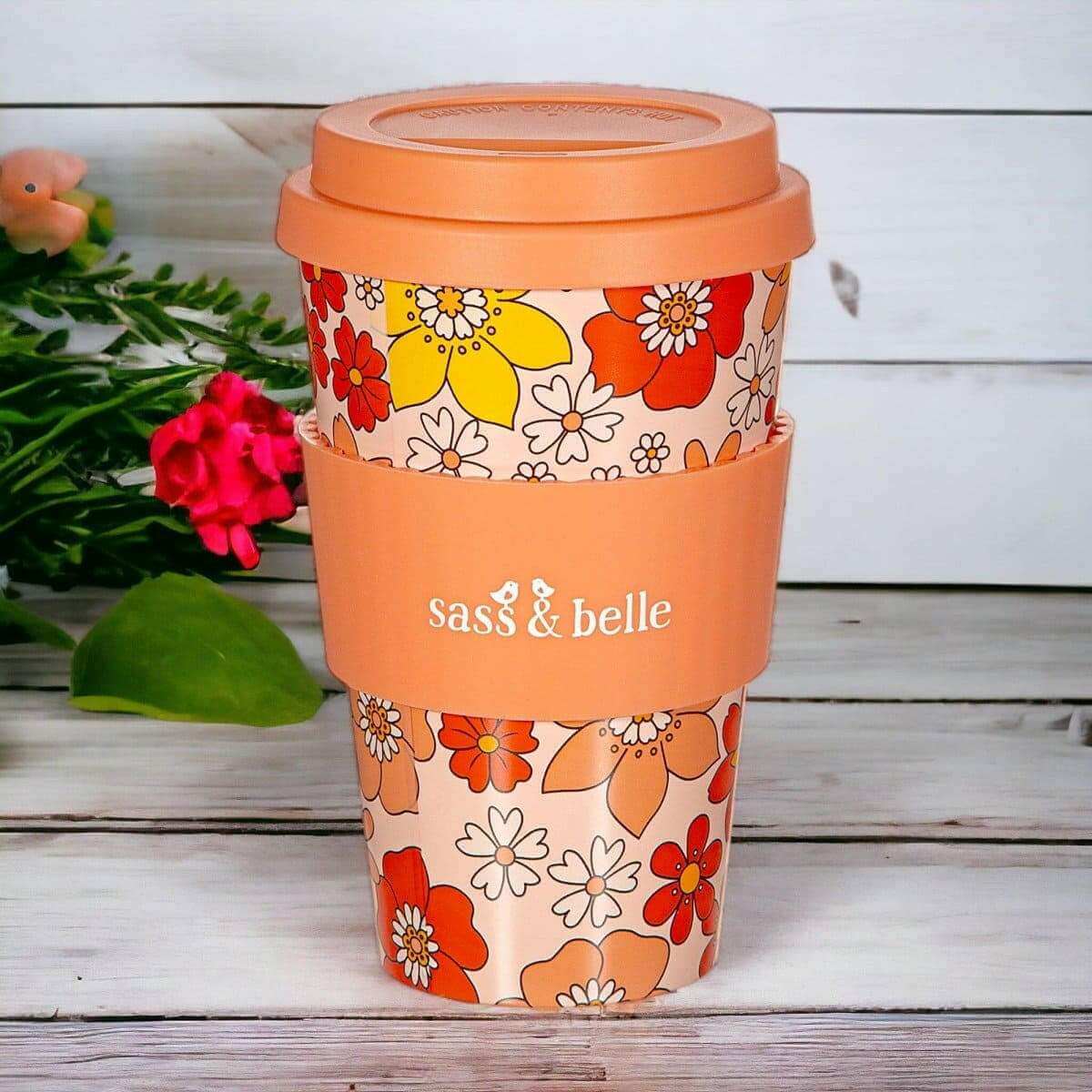 Eco reusable travel mug with orange floral sleeve, domed lid, and Sass & belle branding