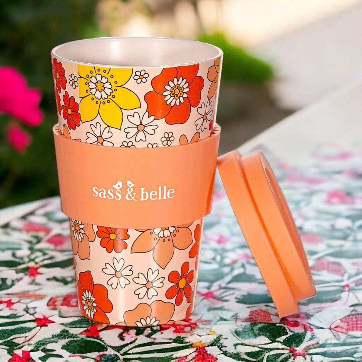 Eco reusable travel mug with orange floral print, clear lid, and side handle; Sass & belle branding