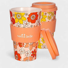Eco reusable travel mug with orange floral pattern, clear lid, and side carry handle; Sass & belle