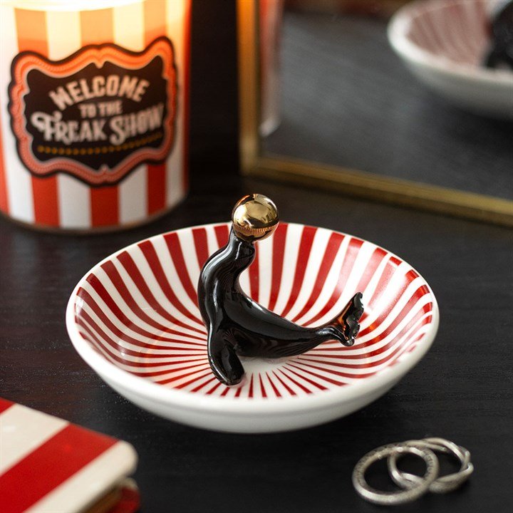 Circus-themed trinket dish with black seal figure and red-and-white striped interior