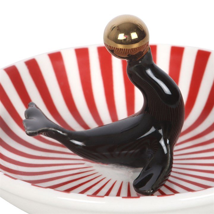 Black seal trinket dish detail: red-striped bowl with gold bulb and raised arms