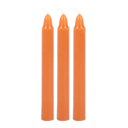 Set of three orange taper candles with smooth cylindrical bodies