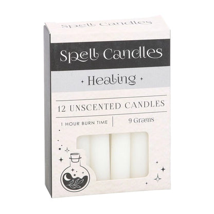 Spell candles box with 12 unscented healing candles, pale cream wax in window
