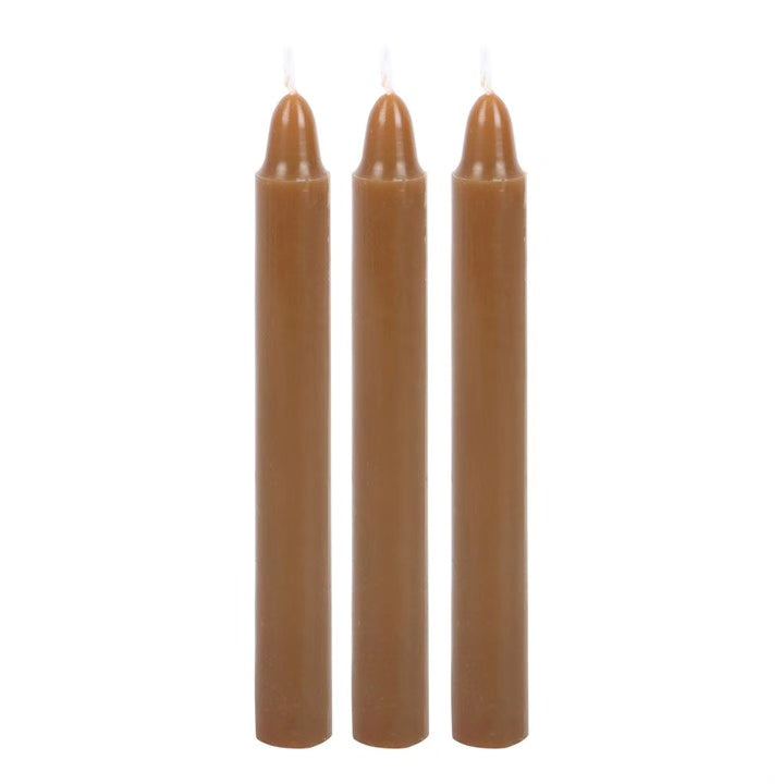 Unscented taper candles in brown with lit wicks, set of three