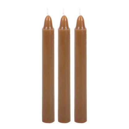 Unscented taper candles in brown with lit wicks, set of three