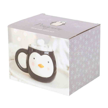Gift set box showing a penguin-themed mug with white face and snowy socks