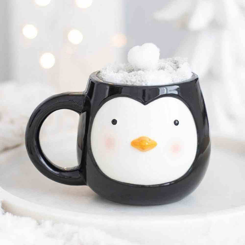 Penguin coffee mug with plush snow hat and penguin face print on black ceramic