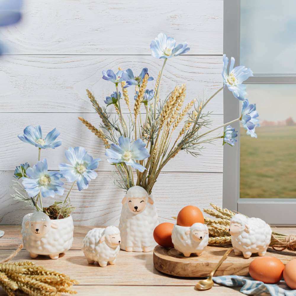 Sheep-shaped egg cups arranged on a rustic breakfast tabletop with eggs