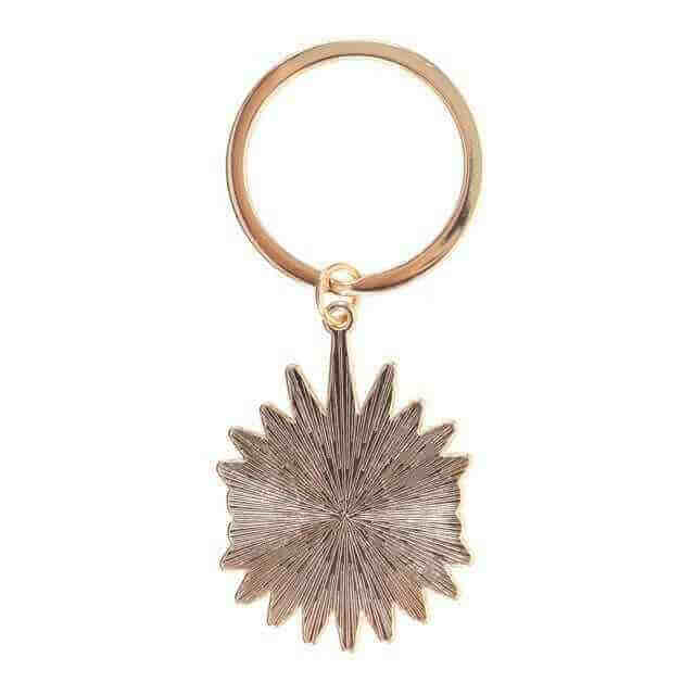 Gold metal keyring with textured sunburst evil eye charm