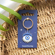 Gold metal keyring with blue enamel evil eye charm, on display card