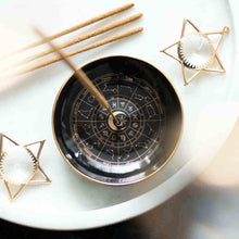 Astrology incense holder set with round black plate, gold rim, zodiac wheel and star stands.