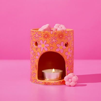 Floral wax melt burner with lit tealight and pink wax melts on top