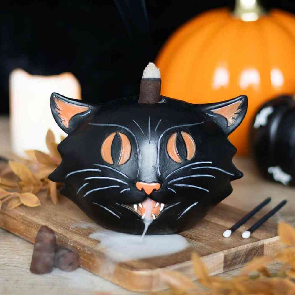 Black cat backflow incense burner on wooden base with incense cone and loose sticks