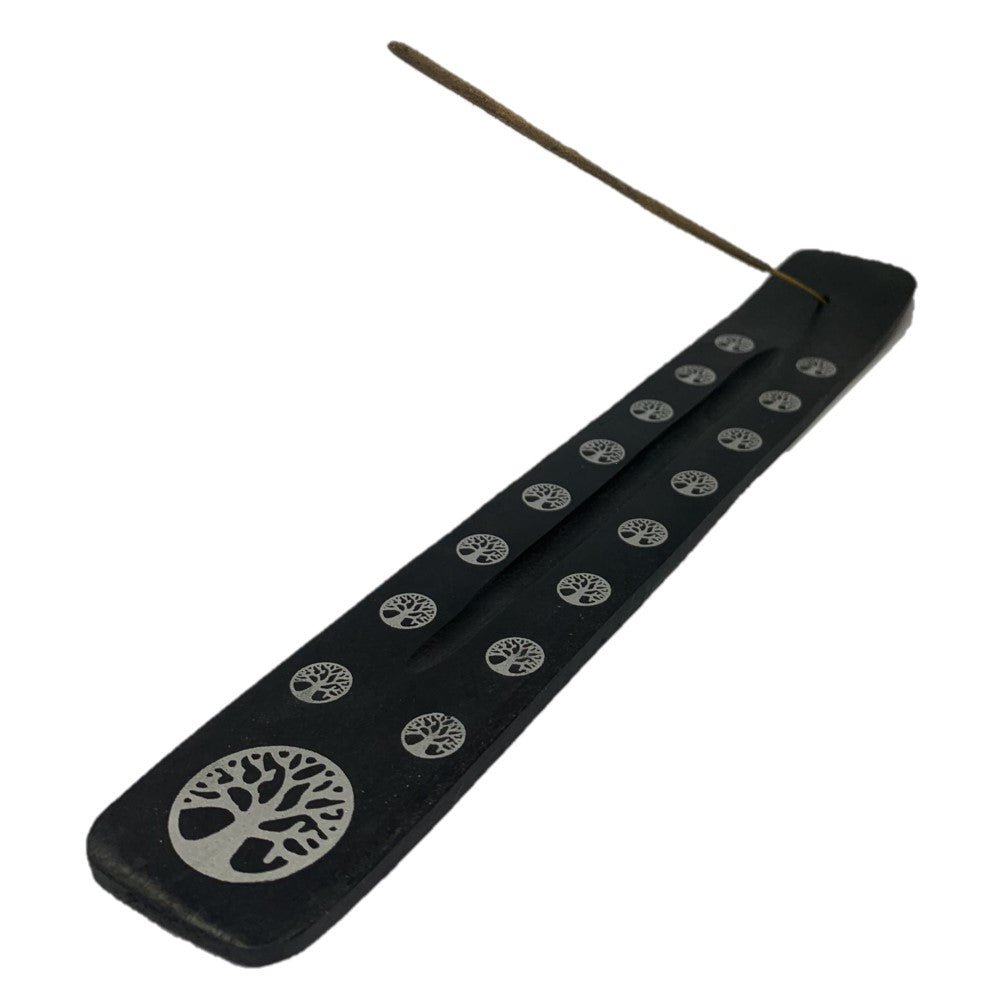 Black wooden incense stick holder with leaf pattern cutout and rows of small symbols
