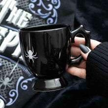 Black gothic-style teacup with spider web symbol, curved batwing handle