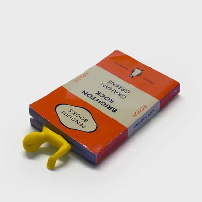 Yellow silicone bookmark figure peeking from orange retail box