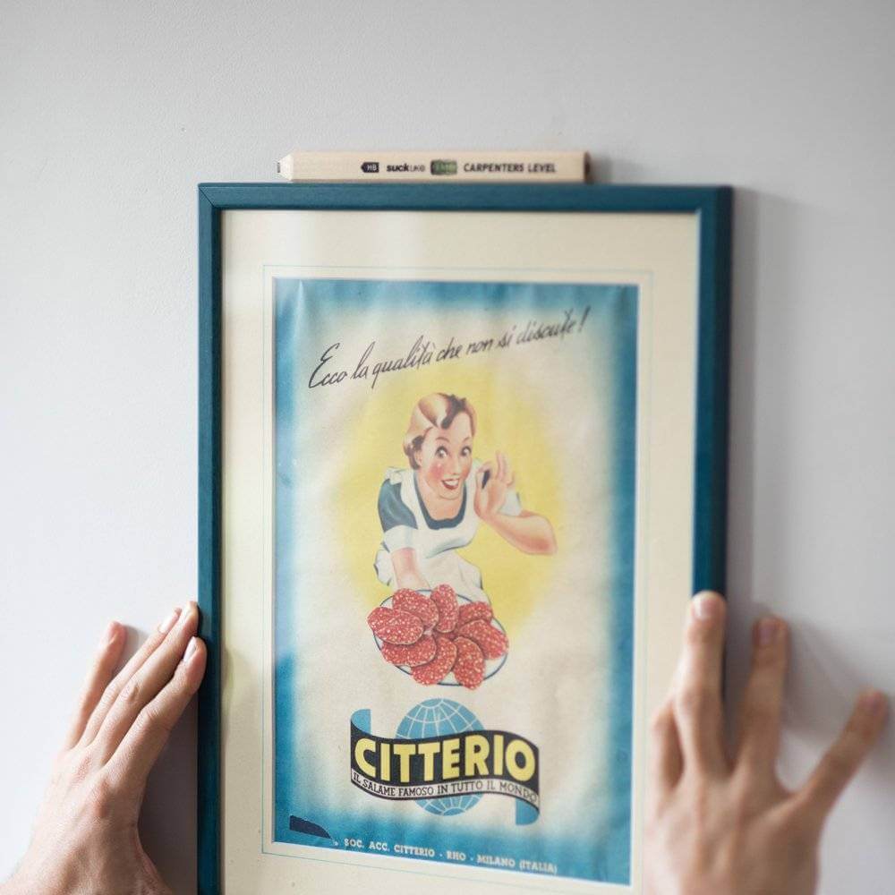 Carpenter's level pencil with spirit vial, resting on a framed artwork.