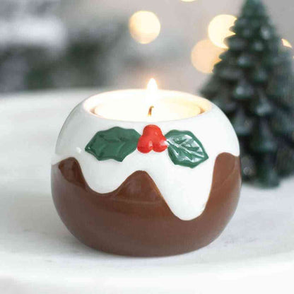 Pudding-shaped tealight holder with lit candle, white top, brown base, green holly decoration