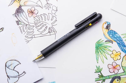 CMYK ballpoint pen with dark barrel and yellow tip, angled on sketch paper