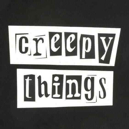 Close-up of 'Creepy Things' logo print on a black polycotton tote bag