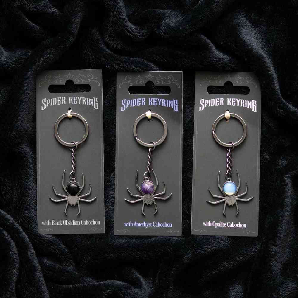Spider keyring set on cards with black, purple, and light-blue cabochon stones