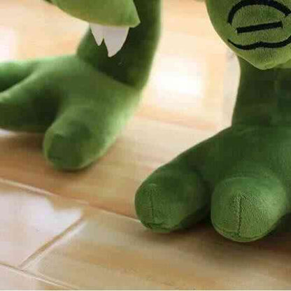 Green T-rex plush toy close-up of legs and tail on a wooden floor