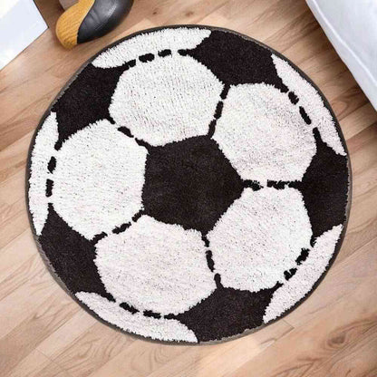 Round football-shaped rug with black-and-white soccer ball design and curved edge border.