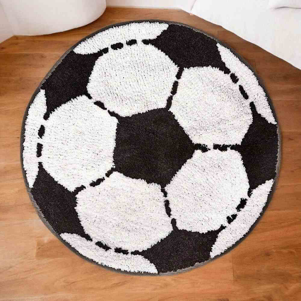 Round football-shaped rug with white soccer balls on a dark background, dashed outlines.