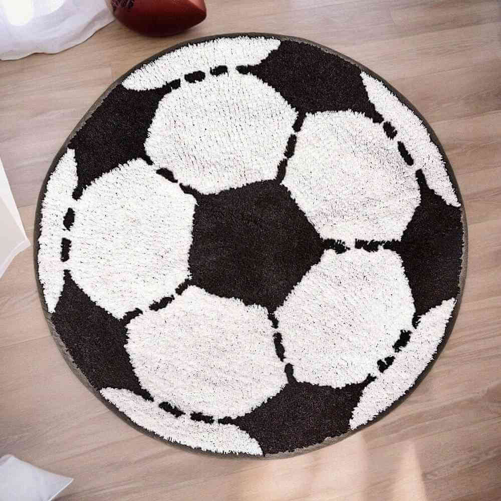 Football-shaped rug with black-and-white soccer ball pattern and round border.