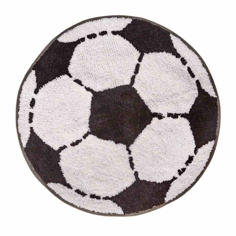 Round football-shaped rug with repeating black-and-white soccer ball motif and dashed stitching.