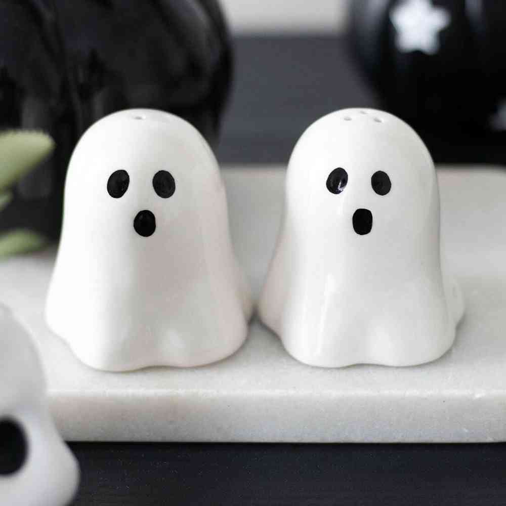 White ghost-shaped salt and pepper shakers with black face, pair on tray