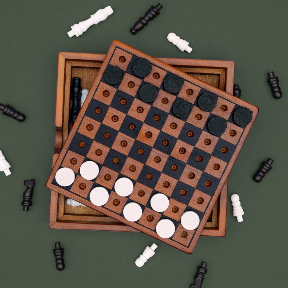 Wooden chess and checkers boards with dark and light discs arranged across the grid