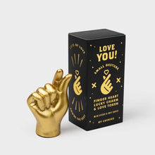 Gold hand lucky charm beside black Love You gift box