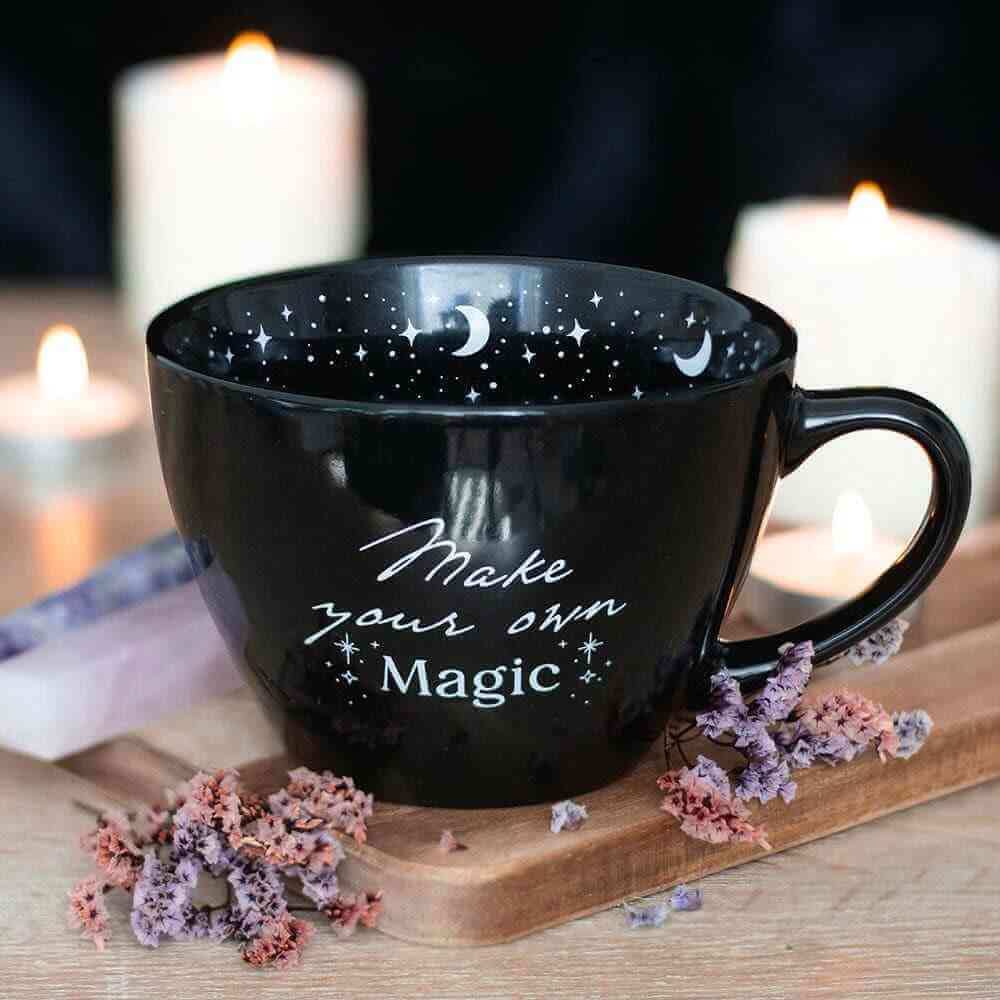 Black ceramic mug with starry moon interior and "Make your own Magic" print