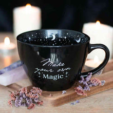 Black ceramic mug with starry moon interior and "Make your own Magic" print
