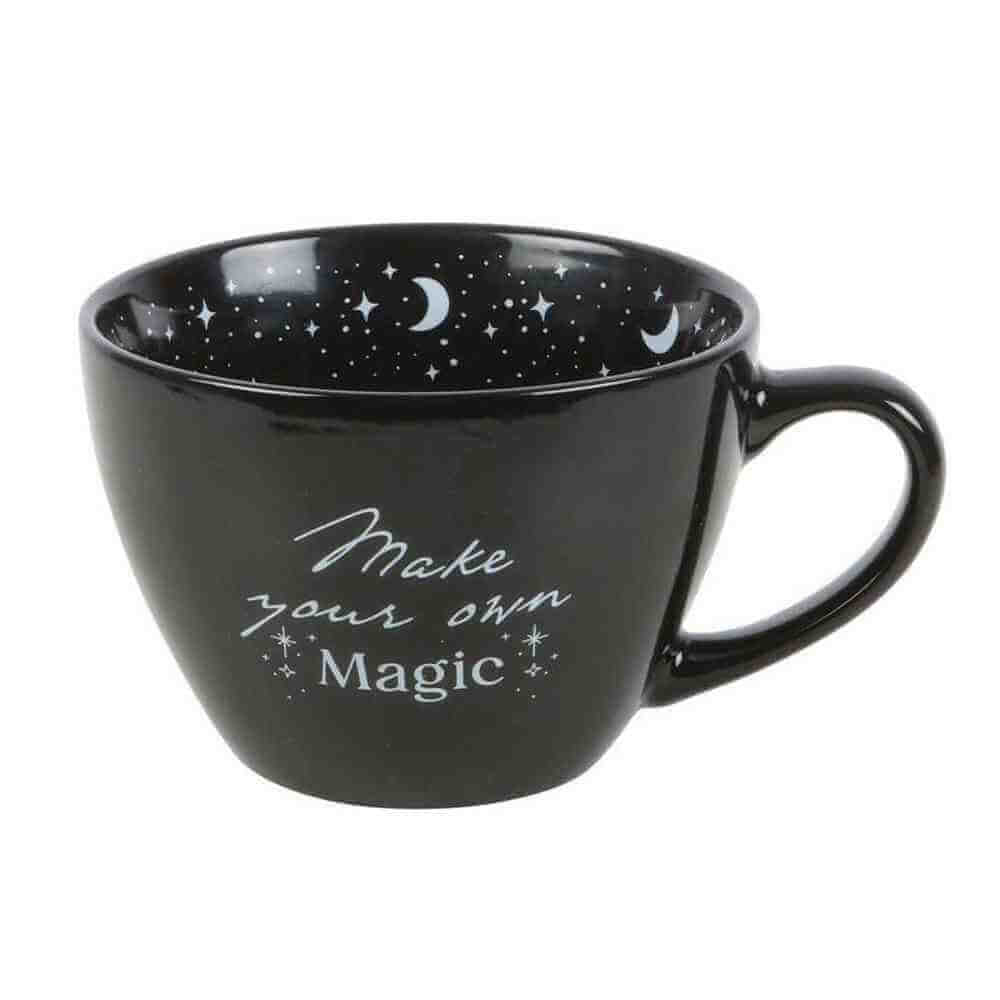 Black ceramic mug with crescent moons and stars, "Make your own Magic" on front