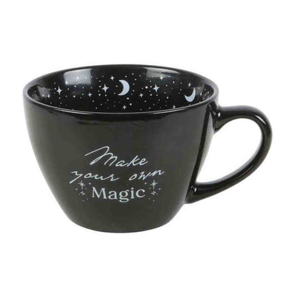 Black ceramic mug with crescent moons and stars, "Make your own Magic" on front
