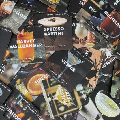 Assorted cocktail recipe coasters with multiple printed drink designs, overlapping.
