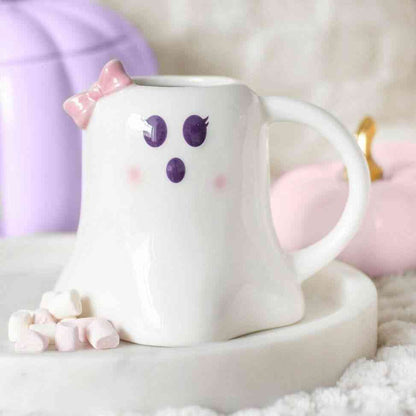 Ghost-shaped mug with purple ghost face, pink bow ears, white ceramic