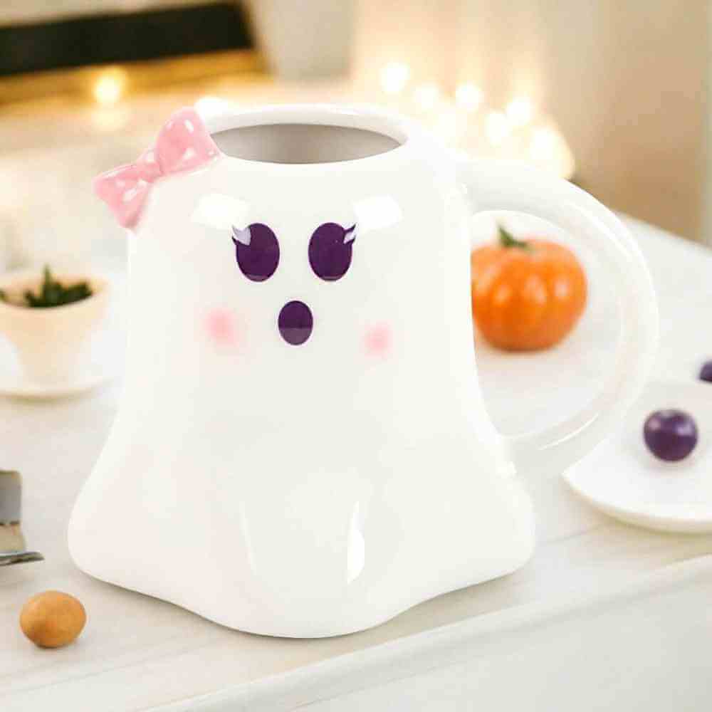 Ghost-shaped mug with pink bow and purple face print, white ceramic
