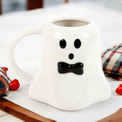 Ghost-shaped ceramic mug, white with black dot eyes and bow smile